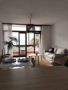 salon z kanapą i stołem w obiekcie La playita, primera linea de mar w Puerto del Carmen