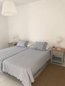 biała sypialnia z 2 łóżkami i 2 stołami w obiekcie La playita, primera linea de mar w Puerto del Carmen
