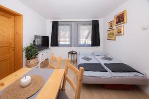 a bedroom with two beds and a dining table at Apartmaji Anže Kranjska Gora in Kranjska Gora
