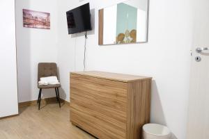 a wooden cabinet in a room with a tv on a wall at Home Sweet Home da Viky in Bari