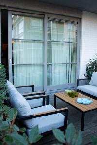a patio with two couches and a coffee table at Appart avec terrasse proche mer in De Panne +10 photos