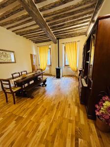 a living room with a wooden floor and a piano at DorminColle - Appartamento in stile toscano in Colle di Val d'Elsa