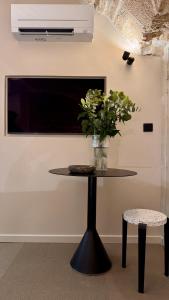 ein Tisch mit einer Vase mit Blumen darauf in der Unterkunft Luxury Suite 2BR in Charming Courtyard Le Marais in Paris