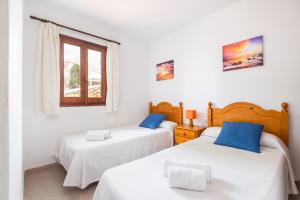 a bedroom with two beds and a window at Villa Catalina by Escape Home in Alaior