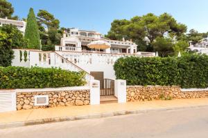 a white house with a stone wall and stairs at Villa Catalina in Alaior
