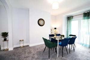 LincolnshireにあるVictoria and Albert 4 Bedroom Houseのテーブルと椅子と時計のあるダイニングルーム