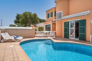 a villa with a swimming pool and a house at Villa Cristina in Cala Blanca