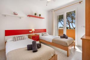 a bedroom with two beds and a window at Villa Cristina in Cala Blanca +24 photos