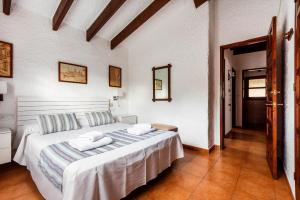 a bedroom with a large white bed in a room at Villa Can Biel by Escape Home in Cala Morell +18 photos