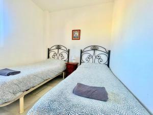 due letti singoli in una stanza con tre tete e tre tete e tre e tre e tre. di Dúplex Hoyo - Islantilla Golf a Islantilla