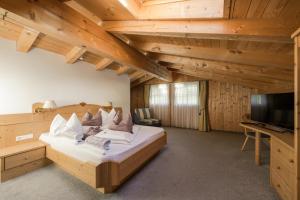a large bedroom with a bed and a tv at Naturhotel Gruberhof in Schenna