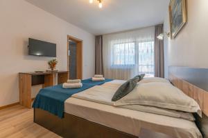 een slaapkamer met een groot bed en een tv aan de muur bij Rare Forest Retreat & Spa in Bran +94 foto's