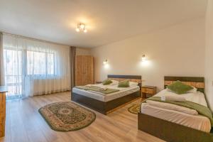 a bedroom with two beds and a large window at Rare Forest Retreat & Spa- Bran in Bran +92 photos