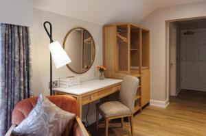 a room with a desk and a mirror and a chair at The Malone Hotel in Belfast