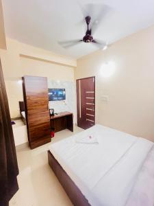 a bedroom with a large bed and a desk at Sunflower Guest House in Guwahati
