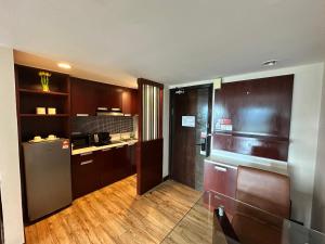 una cucina con armadi in legno e frigorifero di Ming Greenage Suite 明绿时代套房 @Kota Kinabalu 亚庇市中心 a Kota Kinabalu
