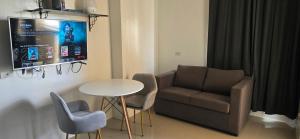 a living room with a couch and a table and chairs at Mabolo Garden Flats Bnb in Cebu City