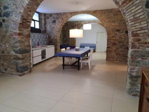 a kitchen and dining room with a table and a brick wall at A 20 passi dal mare in Giardini Naxos