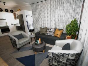 a living room with two chairs a couch and a table at Retro Rhythm - Mossel Cove in Mossel Bay +17 photos