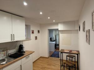 a kitchen with white cabinets and a small table at Ferienwohnung Graf in Egling