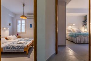 a bedroom with two beds and a mirror at Eleni's town apartment in Skopelos Town