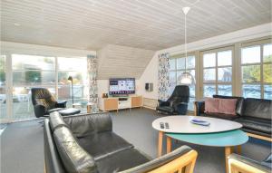 a living room with leather furniture and a table at Awesome Home In Blåvand With Sauna in Blåvand