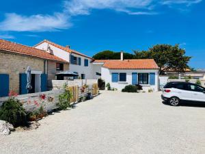 拉康提内勒Clos des Aigrettes -6 Gîtes de charme et confort à 30m du Port de La Cotinière的停在房子前面的车道上的汽车