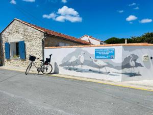 a bike parked next to a wall with a mural of birds at Residence Clos des Aigrettes -Appartements a 30m du Port de La Cotiniere , Ile d Oleron -commerces et plages a pied in La Cotinière +172 photos