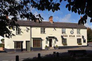 a white building on the corner of a street at The Star Inn 1744 in Thrussington