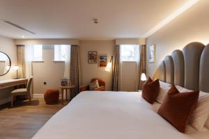 a bedroom with a large bed and a desk at The Malone Hotel in Belfast