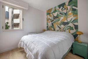 ル・プリガンにあるLa Baule plage Benoit- Appartement pour 6の白いベッドと窓のある寝室