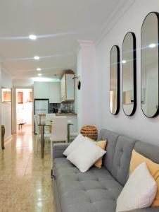 ein Wohnzimmer mit einem Sofa und Spiegeln an der Wand in der Unterkunft La Cabaña de la Antilla II in La Antilla