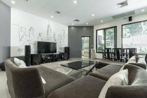 Una sala de estar con un sofá y un televisor. en Villa Andre by VillaCarte, en Nai Harn Beach