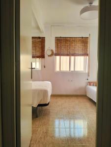 ein Schlafzimmer mit zwei Betten und einem Fenster in der Unterkunft La Cabaña de la Antilla II in La Antilla + 14 Fotos