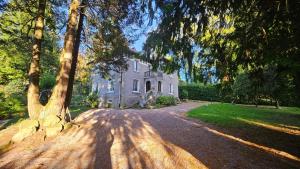 an old house with a tree in front of it at Le Pavillon dans le Parc in Saulxures-sur-Moselotte