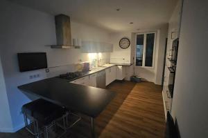 a kitchen with a table and a clock on the wall at Le Pavillon dans le Parc in Saulxures-sur-Moselotte