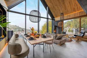 a living room with a table and chairs and windows at Coalhouse Pfalz in Sankt Martin