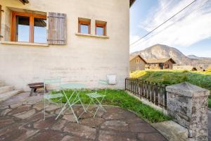 a patio with a table and chairs in front of a house at Au centre cosy et neuf proche station ski parking terasse in Taninges