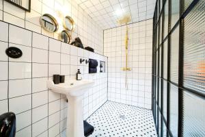 a white bathroom with a sink and a mirror at Lab Loft à Bastille 110m2 in Paris