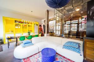 a living room with a white couch and blue pillows at Lab Loft à Bastille 110m2 in Paris