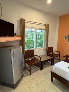 a room with a bed and chairs and a window at Lanta Island Resort in Ko Lanta