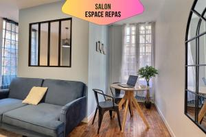 a living room with a couch and a table with a laptop at Le logis de Madeleine - ideal couple / solo - coeur de la ville - proche gare in Troyes +26 photos