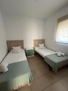 a room with two beds and a window at Chalet en C.Vadella - Piscina privada in Cala Vadella