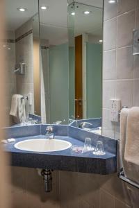 a bathroom with a sink and a large mirror at Holiday Inn Express Royal Docks by IHG in London