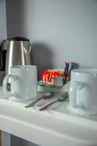 two coffee cups and a tea kettle on a table at Holiday Inn Express Royal Docks by IHG in London