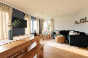 una sala de estar con un sofá y una mesa en Secluded Sanctuary On The River, en Christchurch