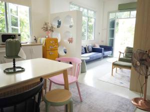a living room with colorful chairs and a table at Lamp U House Amphawa in Amphawa