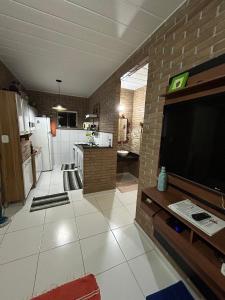 a living room with a flat screen tv on a brick wall at Casa agradável em um condomínio na barra do sana. in Sana