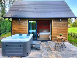 a gazebo with a hot tub on a patio at ptit cocon in Le Fournet