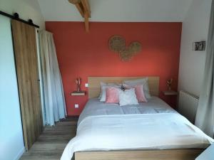 a bedroom with a large bed with a red wall at ptit cocon in Le Fournet